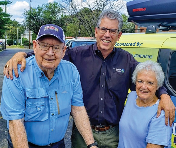 Two men and one woman posing for photo