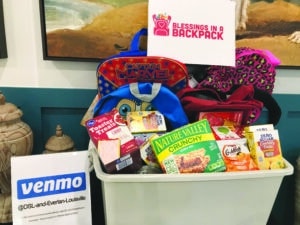 A bin full of donated packaged snacks for children, such as granola bars and Goldfish. 
