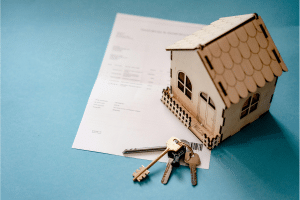 Model house with keys and documents